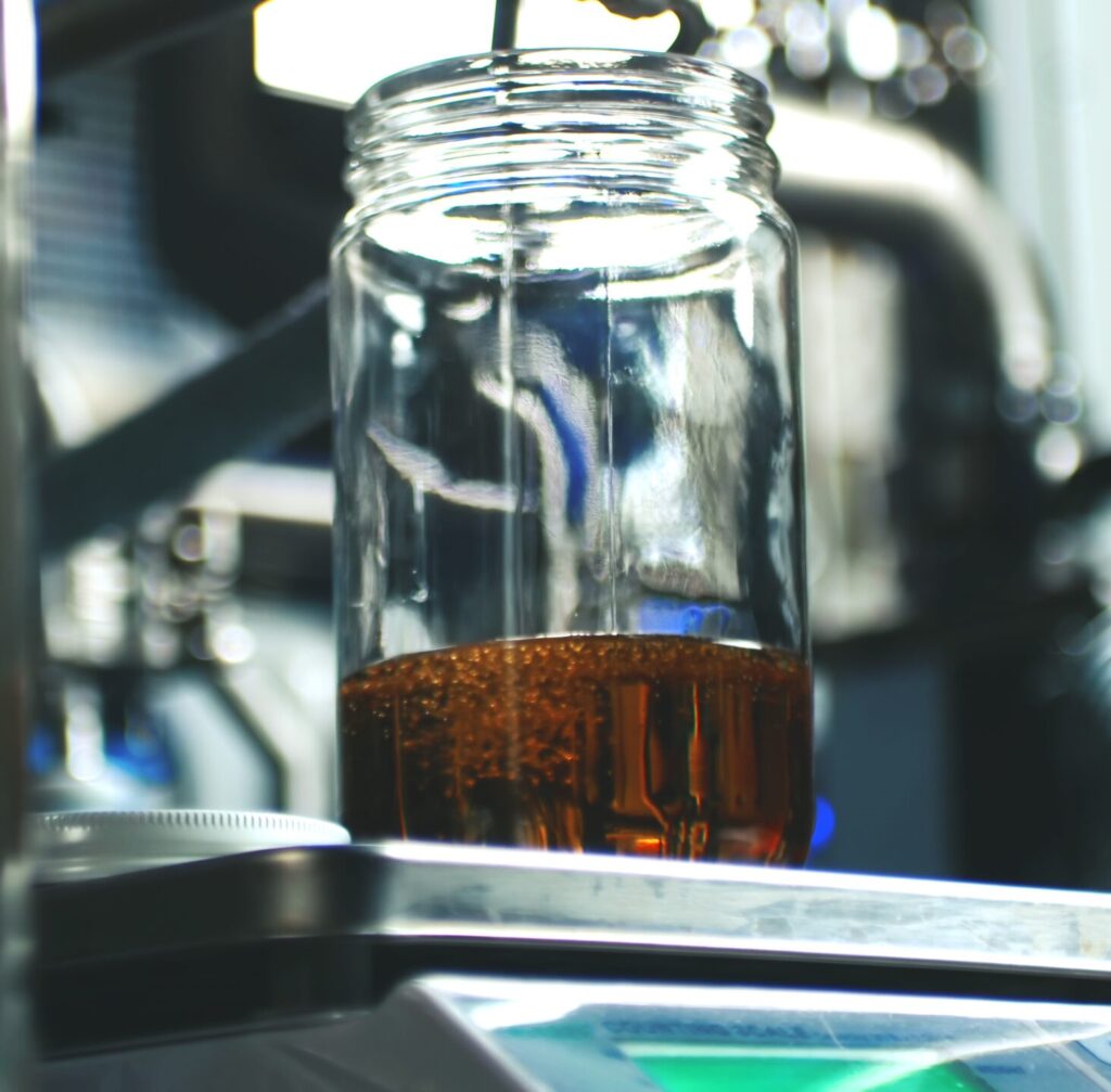 Cannabis extract collected in glass jar during post-processing distillation