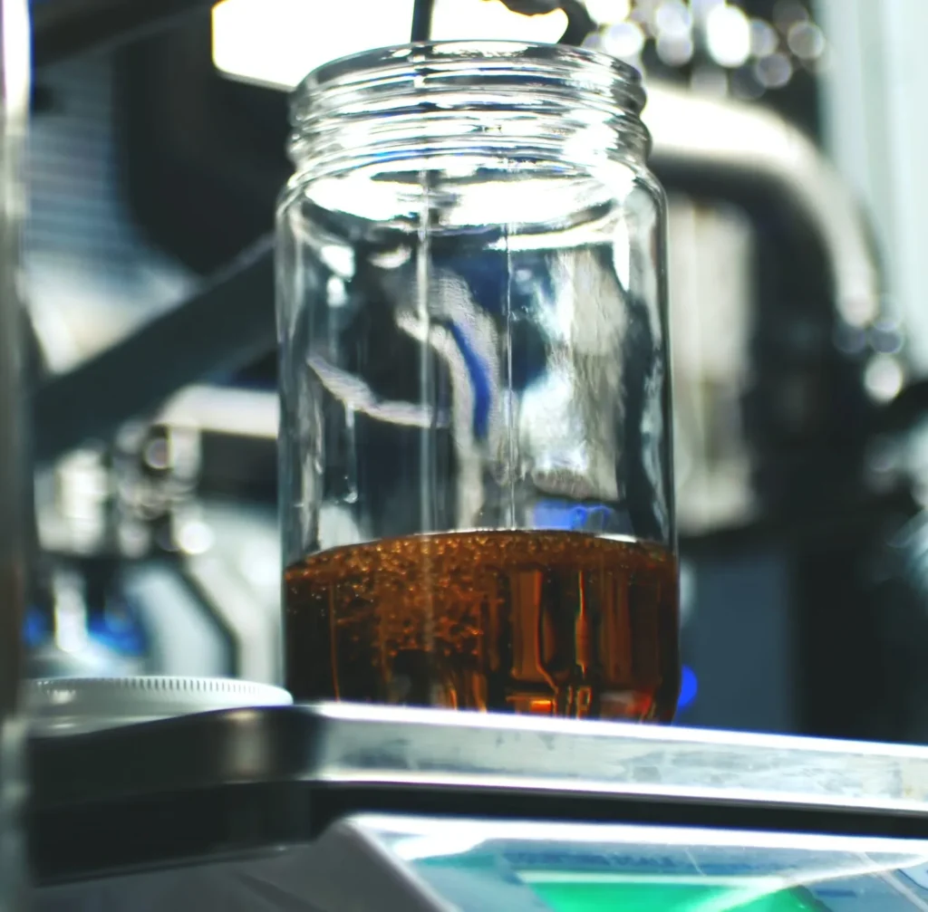Cannabis extract collected in glass jar during post-processing distillation